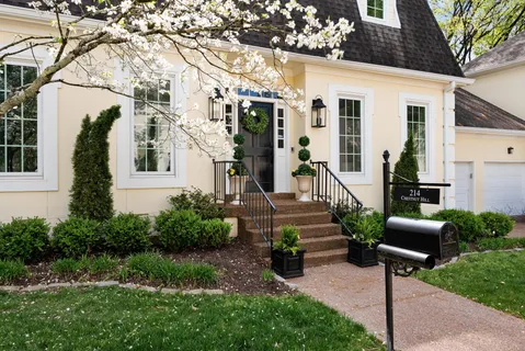 a front view of a house with garden and plants