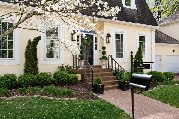 a front view of a house with garden and plants