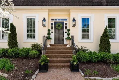 a front view of a house with plants