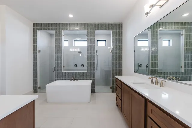 a bathroom with a bathtub shower sink and mirror