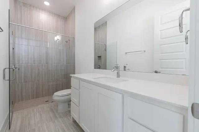 a bathroom with a sink a toilet and shower