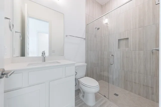 a bathroom with a sink a toilet and shower