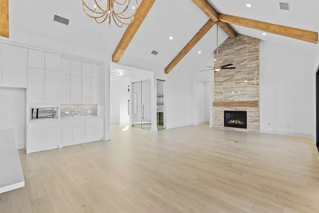 a view of an empty room with a fireplace and a window