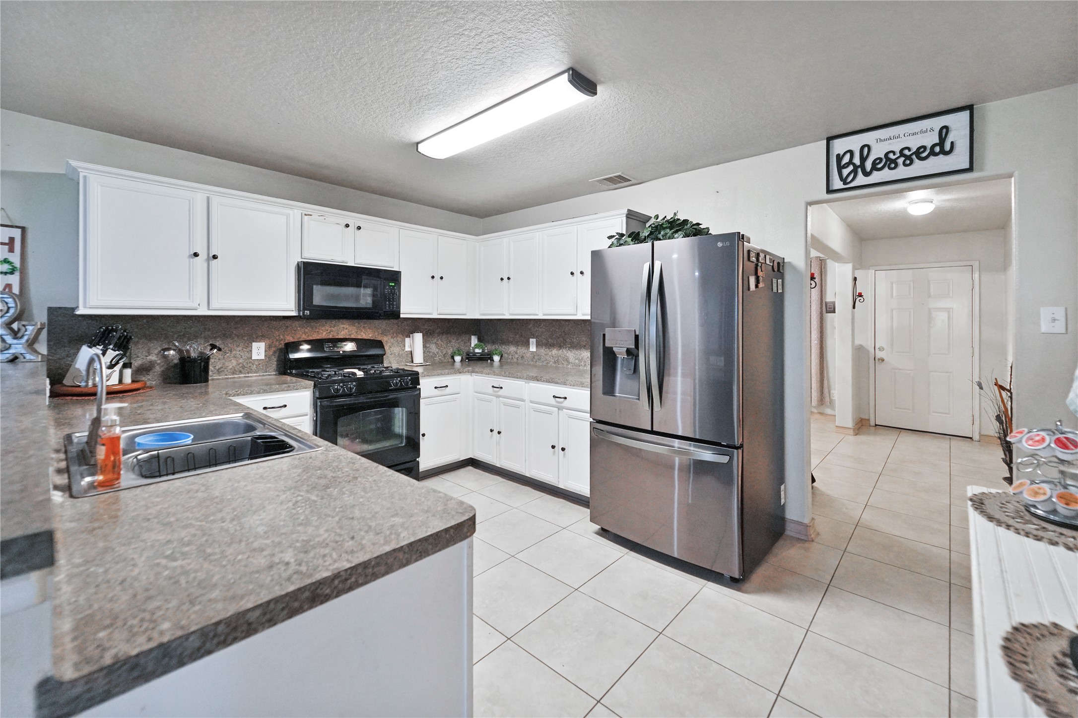8011 Sumal Circle Baytown, TX 77521 - Photo 6 of 37 a kitchen with stainless steel appliances granite countertop a refrigerator sink and stove