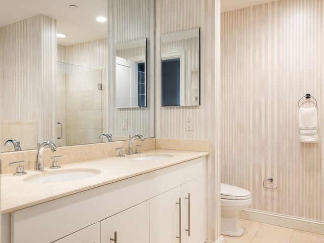 a bathroom with a granite countertop sink toilet and shower