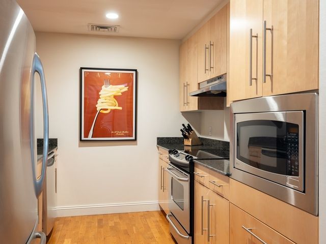 a kitchen with stainless steel appliances granite countertop a refrigerator and a stove top oven
