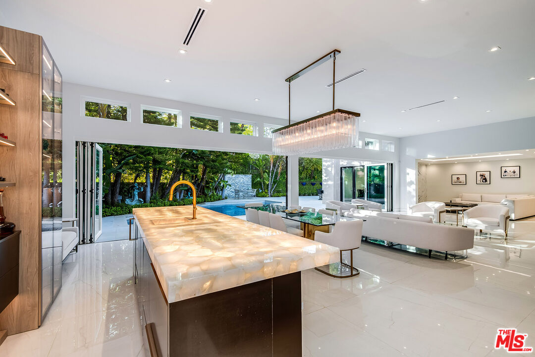 16601 Park Ln Circle Los Angeles, CA 90049 - Photo 12 of 69 a view of a dining room with furniture large windows and wooden floor