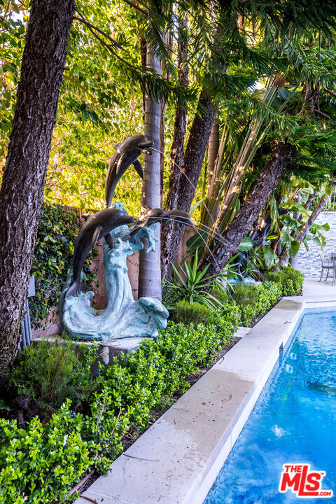 16601 Park Ln Circle Los Angeles, CA 90049 - Photo 18 of 69 a view of a yard with plants and large trees