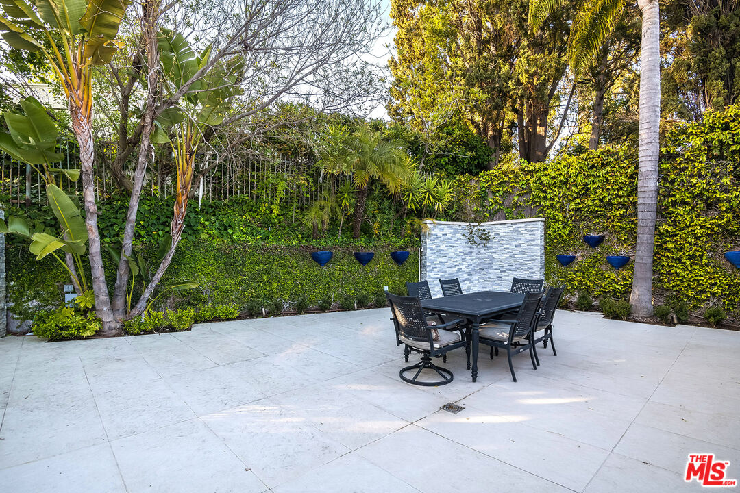 16601 Park Ln Circle Los Angeles, CA 90049 - Photo 22 of 69 a view of a patio with table and chairs and potted plants