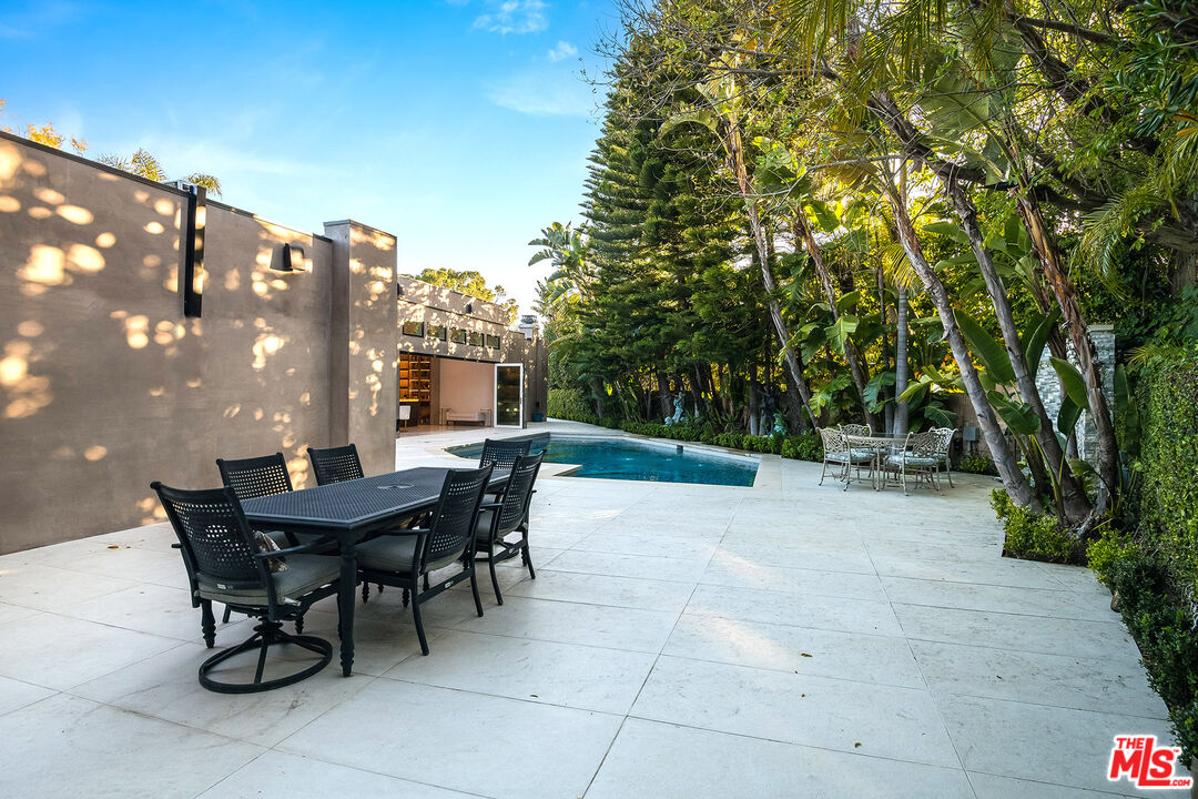 16601 Park Ln Circle Los Angeles, CA 90049 - Photo 23 of 69 a view of a patio with table and chairs and potted plants