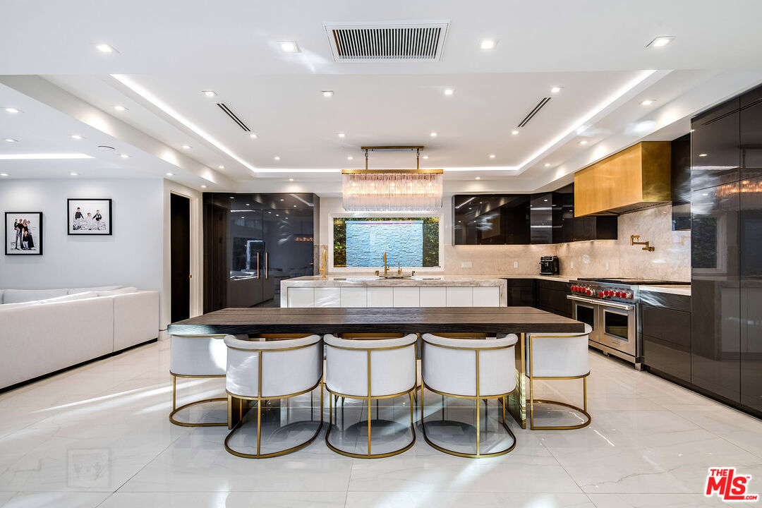 16601 Park Ln Circle Los Angeles, CA 90049 - Photo 28 of 69 a kitchen with stainless steel appliances kitchen island granite countertop a sink and cabinets
