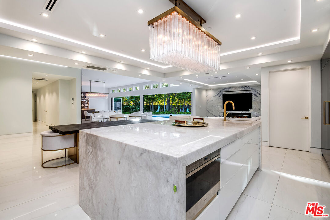 16601 Park Ln Circle Los Angeles, CA 90049 - Photo 30 of 69 a large kitchen with a large counter top appliances and cabinets