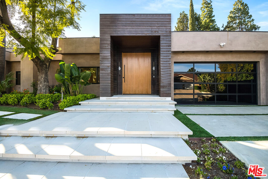 16601 Park Ln Circle Los Angeles, CA 90049 - Photo 3 of 69 a front view of a house with garden