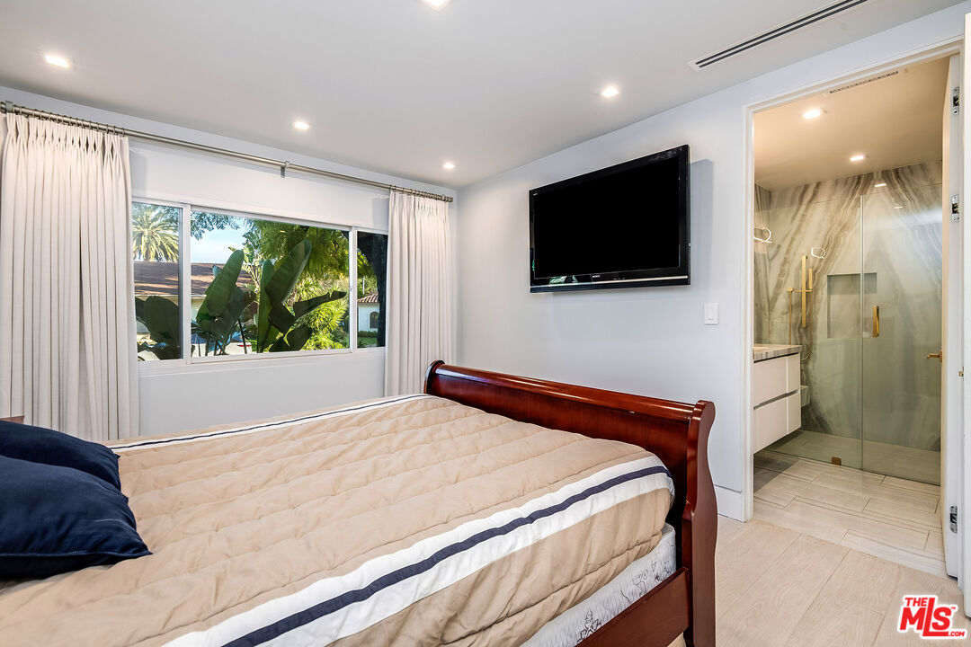 16601 Park Ln Circle Los Angeles, CA 90049 - Photo 35 of 69 a bedroom with a large bed and a flat screen tv