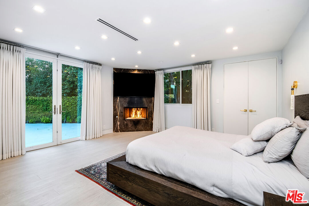 16601 Park Ln Circle Los Angeles, CA 90049 - Photo 37 of 69 a spacious bedroom with a bed and a large window