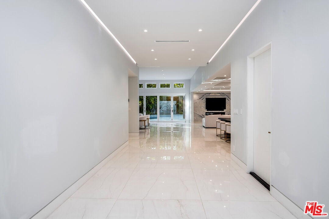 16601 Park Ln Circle Los Angeles, CA 90049 - Photo 4 of 69 a view of a hallway with wooden floor fireplace and a sink
