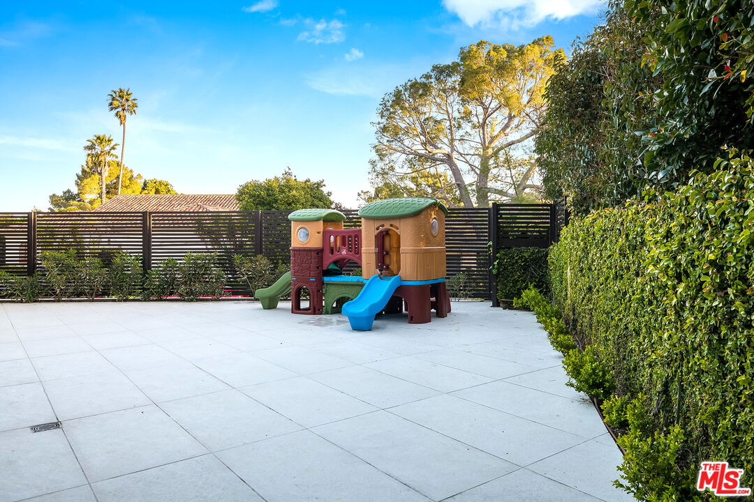 16601 Park Ln Circle Los Angeles, CA 90049 - Photo 44 of 69 a view of a chair and table in the back yard of the house
