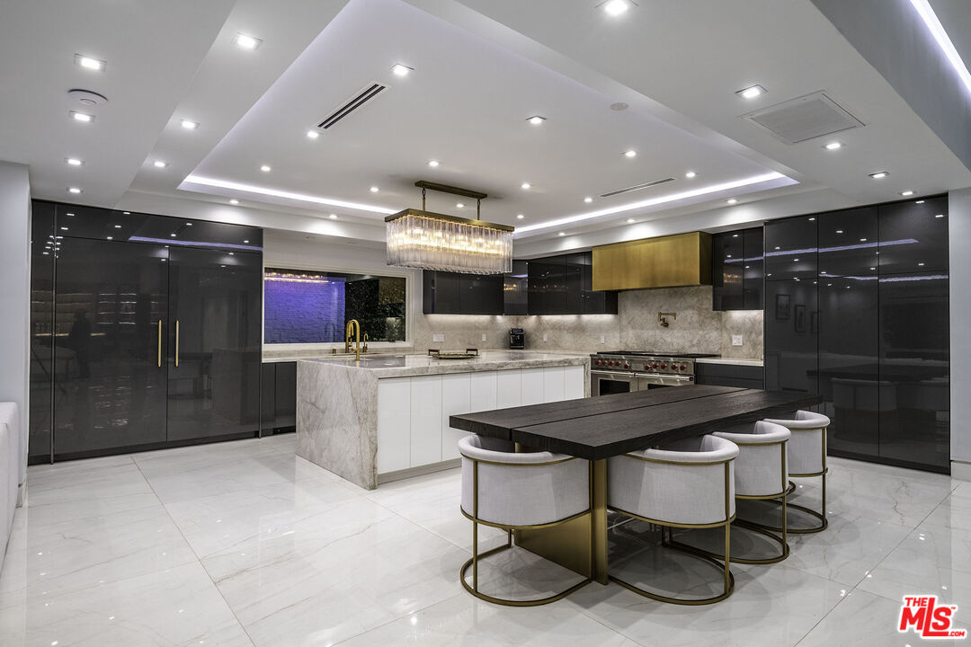 16601 Park Ln Circle Los Angeles, CA 90049 - Photo 63 of 69 a kitchen with stainless steel appliances kitchen island granite countertop a sink and cabinets