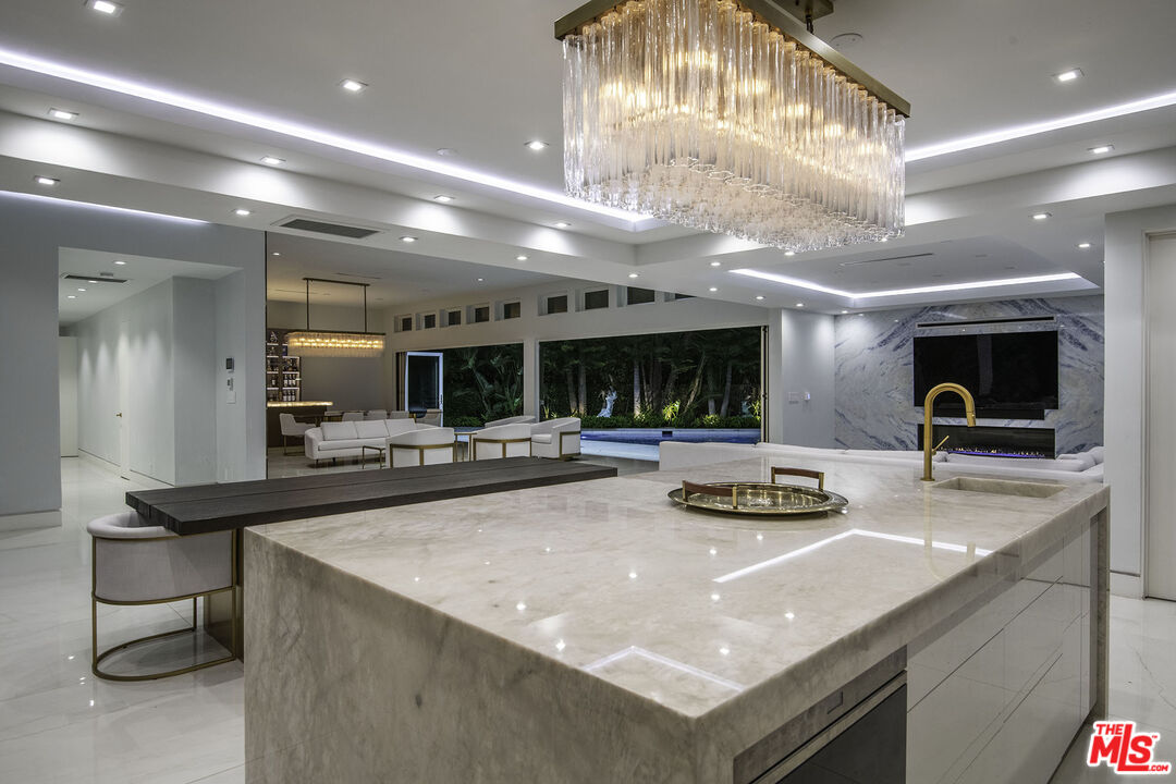 16601 Park Ln Circle Los Angeles, CA 90049 - Photo 66 of 69 a kitchen with a stove a microwave and a dining table