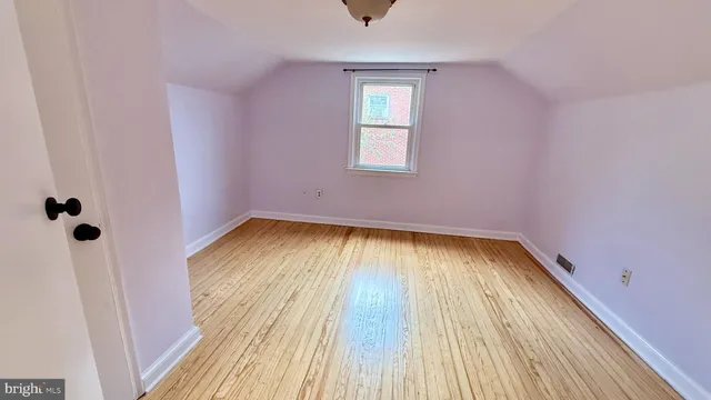 a view of a room with wooden floor and a window