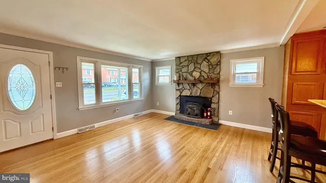 an empty room with fireplace wooden floor and windows