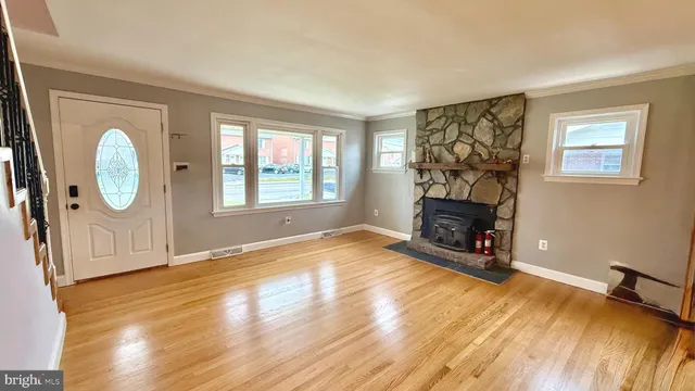 a view of a livingroom with wooden floor and a fireplace