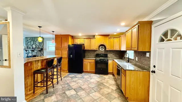 a kitchen with a refrigerator and a stove top oven