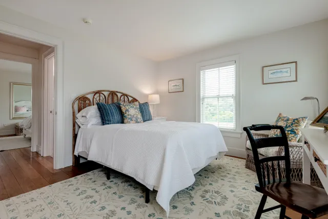 a bedroom with a bed and a dresser next to a window