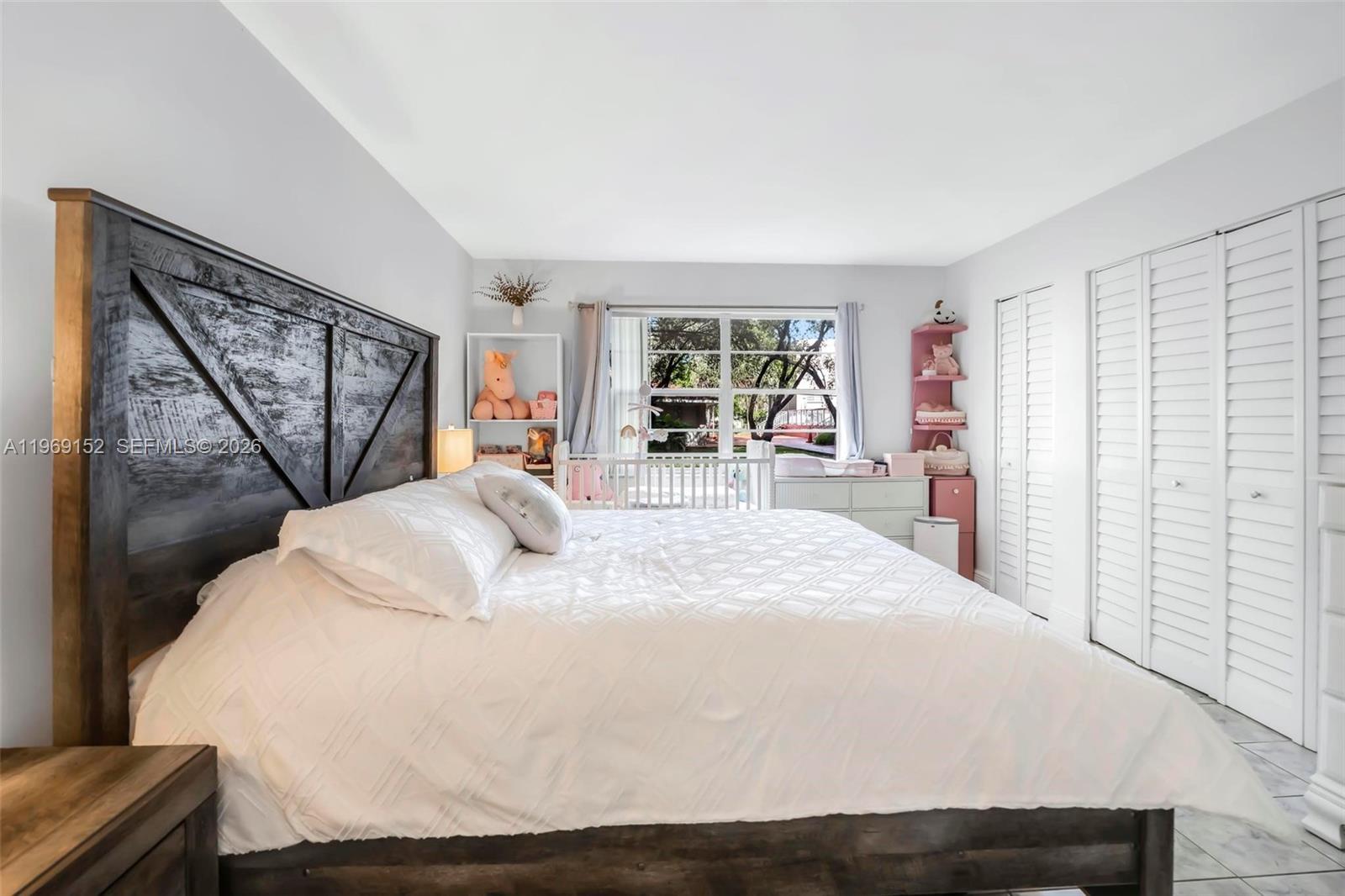 8501 Northwest 8th Street, Unit 110 Miami, FL 33126 - Photo 12 of 21 a bed sitting in a spacious bedroom next to a window