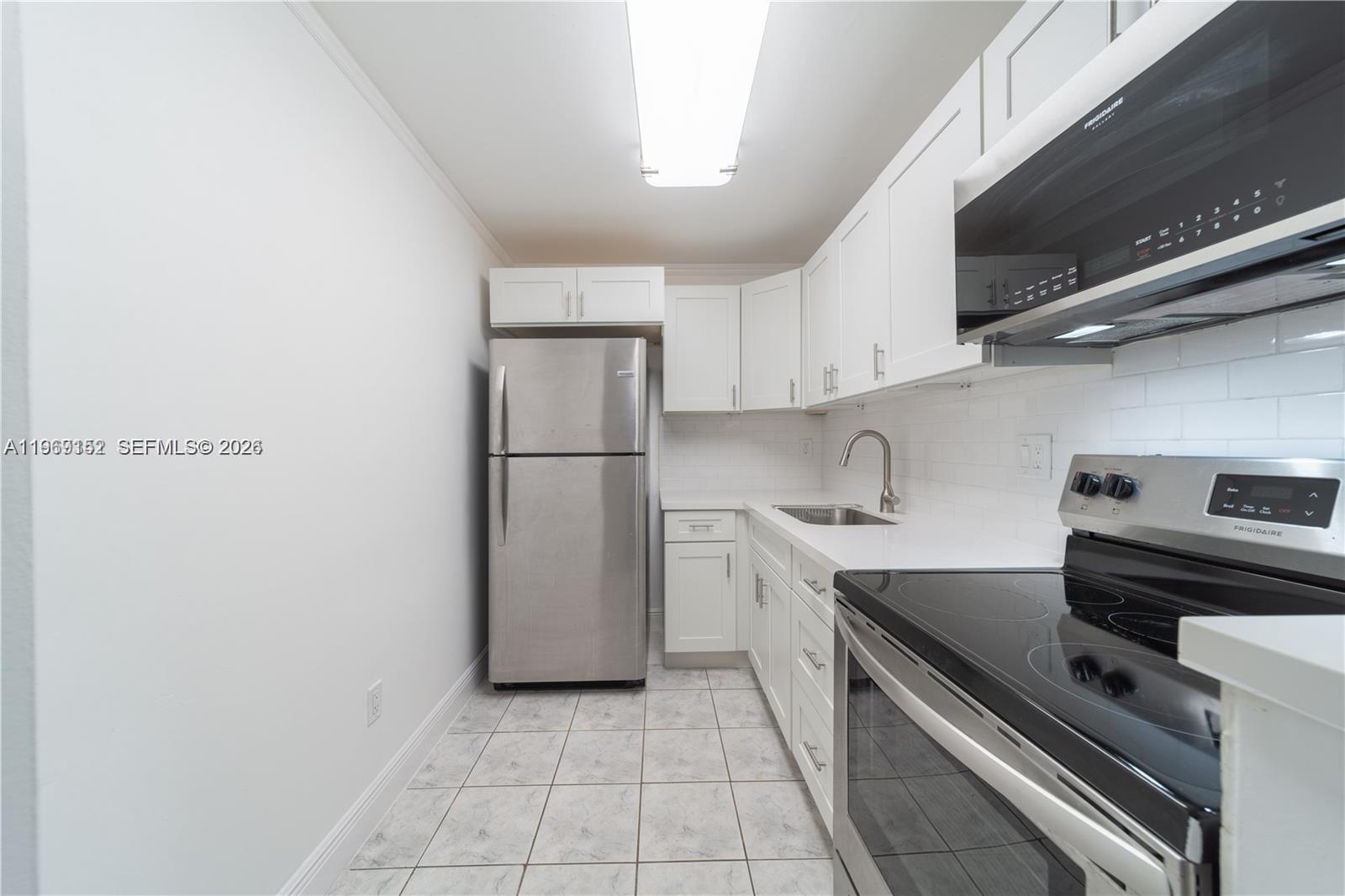 8501 Northwest 8th Street, Unit 110 Miami, FL 33126 - Photo 3 of 21 a kitchen with a stove top oven and refrigerator