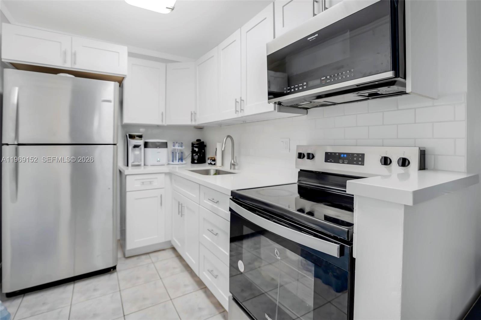 8501 Northwest 8th Street, Unit 110 Miami, FL 33126 - Photo 4 of 21 a kitchen with stainless steel appliances a refrigerator stove and microwave