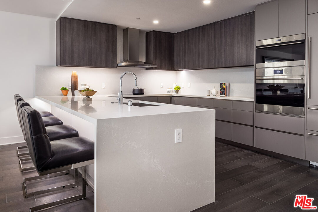411 South Hamel Road, Unit 205 Los Angeles, CA 90048 - Photo 4 of 17 a kitchen with a stove a sink and a microwave
