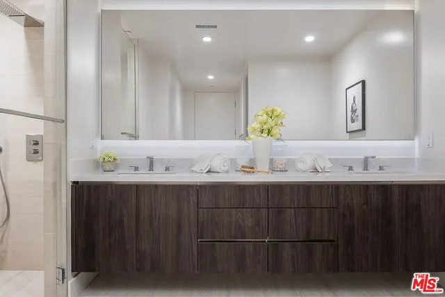 a bathroom with double sink and a mirror