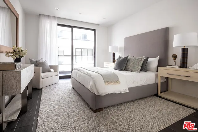 a bedroom with a large bed and a potted plant