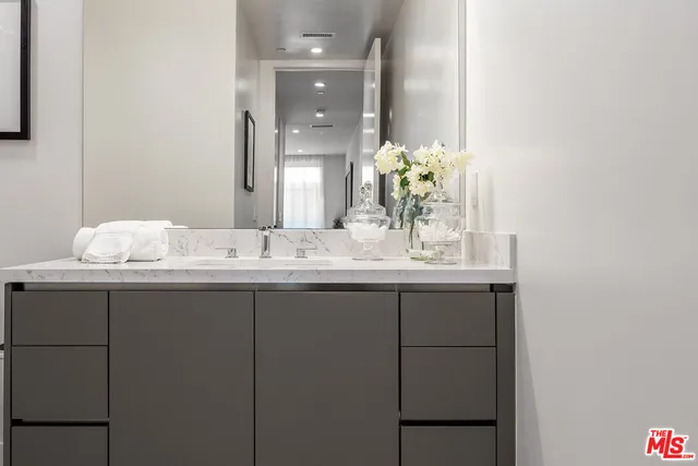 a bathroom with a granite countertop sink and a mirror
