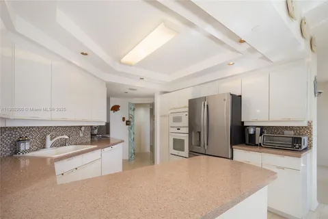 a kitchen with stainless steel appliances granite countertop a refrigerator and a sink