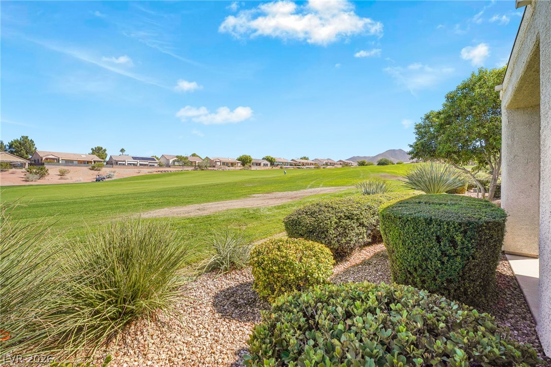 2738 Grand Forks Road Henderson, NV 89052 - Photo 34 of 52 Lush manicured hedges frame scenic views of the rolling green golf course under clear skies.