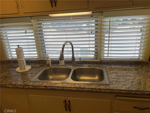 a kitchen sink with granite countertop a sink and a window