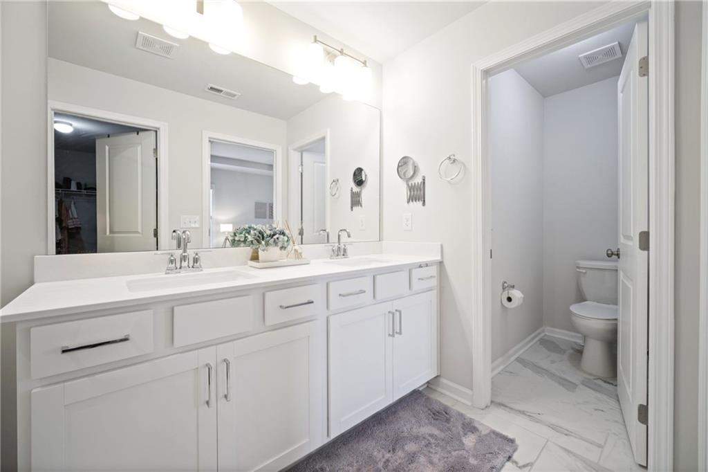 1595 Ridgebrook Downs Mableton, GA 30126 - Photo 22 of 39 a spacious bathroom with a toilet a sink a mirror and a shower