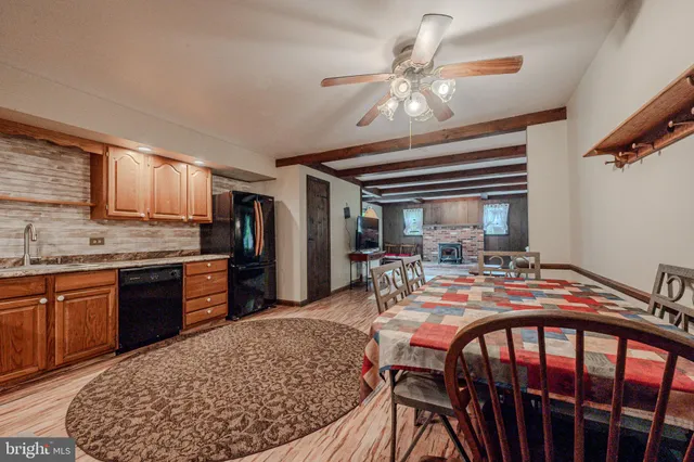 a view of a dining room and livingroom with furniture wooden floor a chandelier