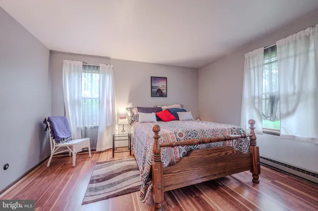 a bedroom with a large bed and a wooden floor