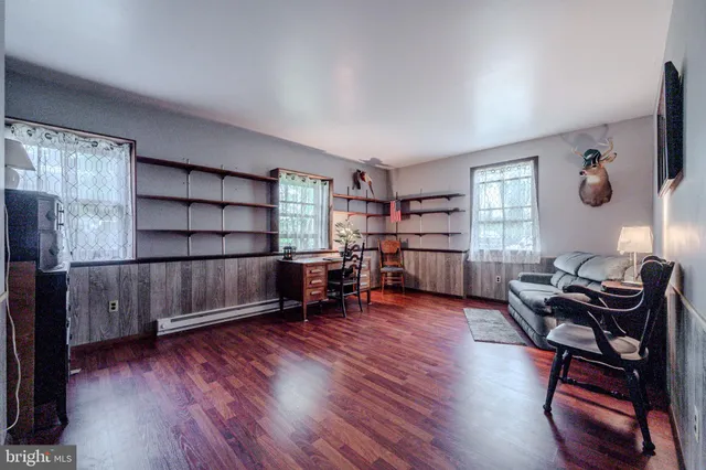 a living room with furniture a piano and a bookshelf