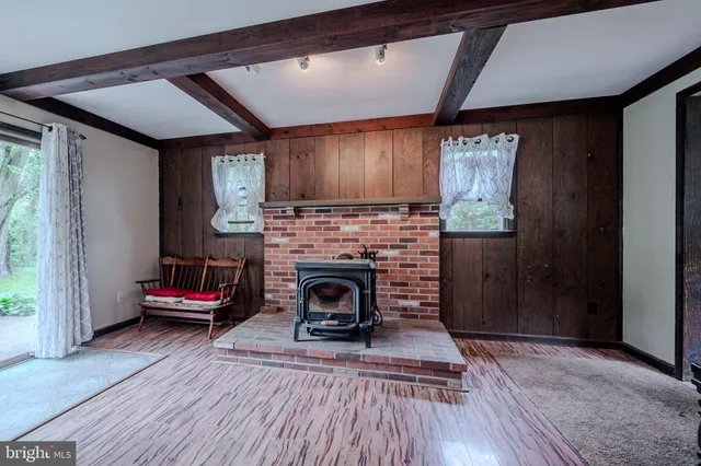 a kitchen with stainless steel appliances a dining table chairs a refrigerator and cabinets