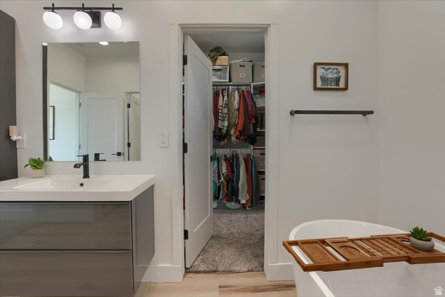 828 South Deer Road Tooele, UT 84074 - Photo 29 of 51 Modern bathroom featuring a floating vanity with a vessel sink and matte black faucet, a large rectangular mirror, and contemporary three-bulb vanity lighting