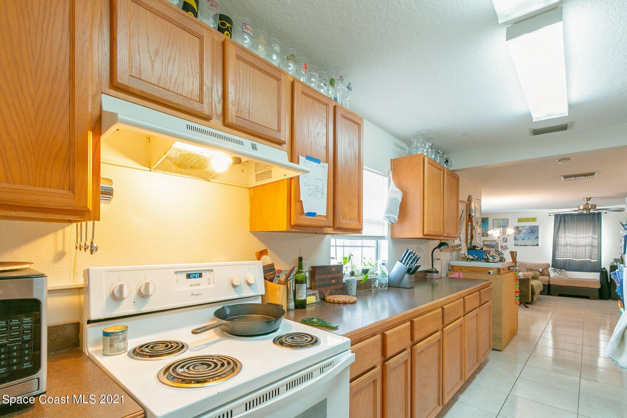 3222 Lipscomb Street Melbourne, FL 32901 - Photo 11 of 27 a kitchen with kitchen island a stove a sink and a refrigerator