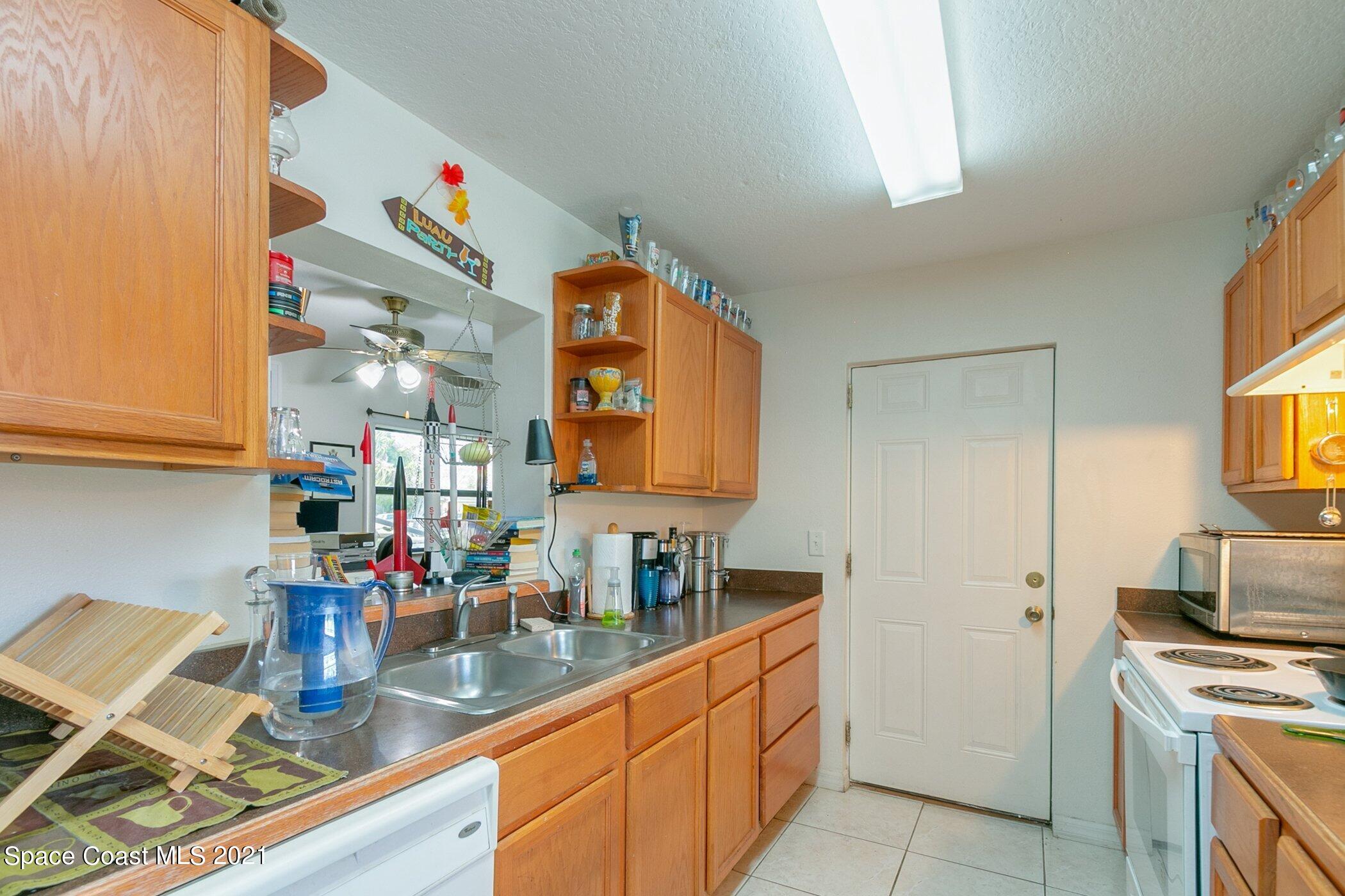 3222 Lipscomb Street Melbourne, FL 32901 - Photo 12 of 27 a kitchen with stainless steel appliances granite countertop a sink stove and cabinets