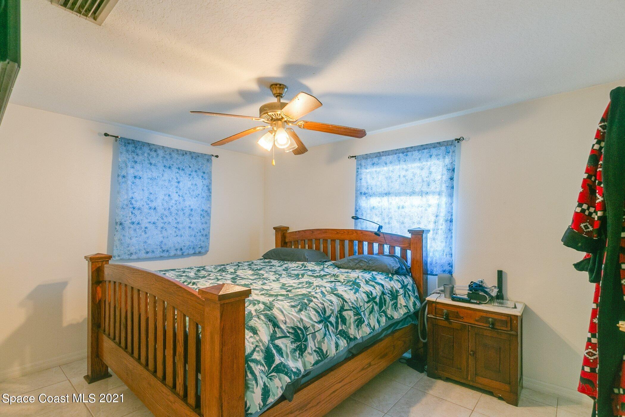 3222 Lipscomb Street Melbourne, FL 32901 - Photo 17 of 27 a bedroom with a bed and a chandelier