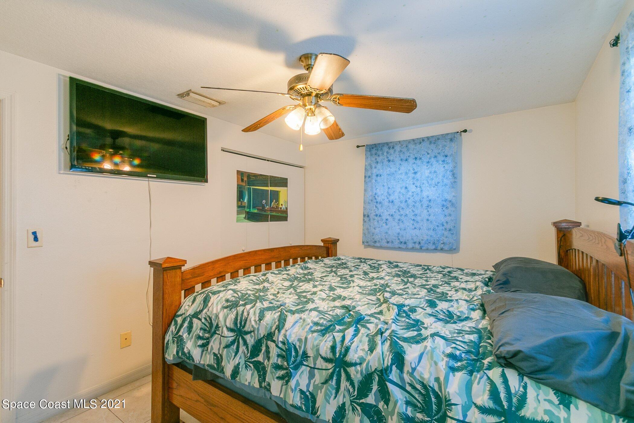 3222 Lipscomb Street Melbourne, FL 32901 - Photo 18 of 27 a bedroom with a bed and a flat screen tv