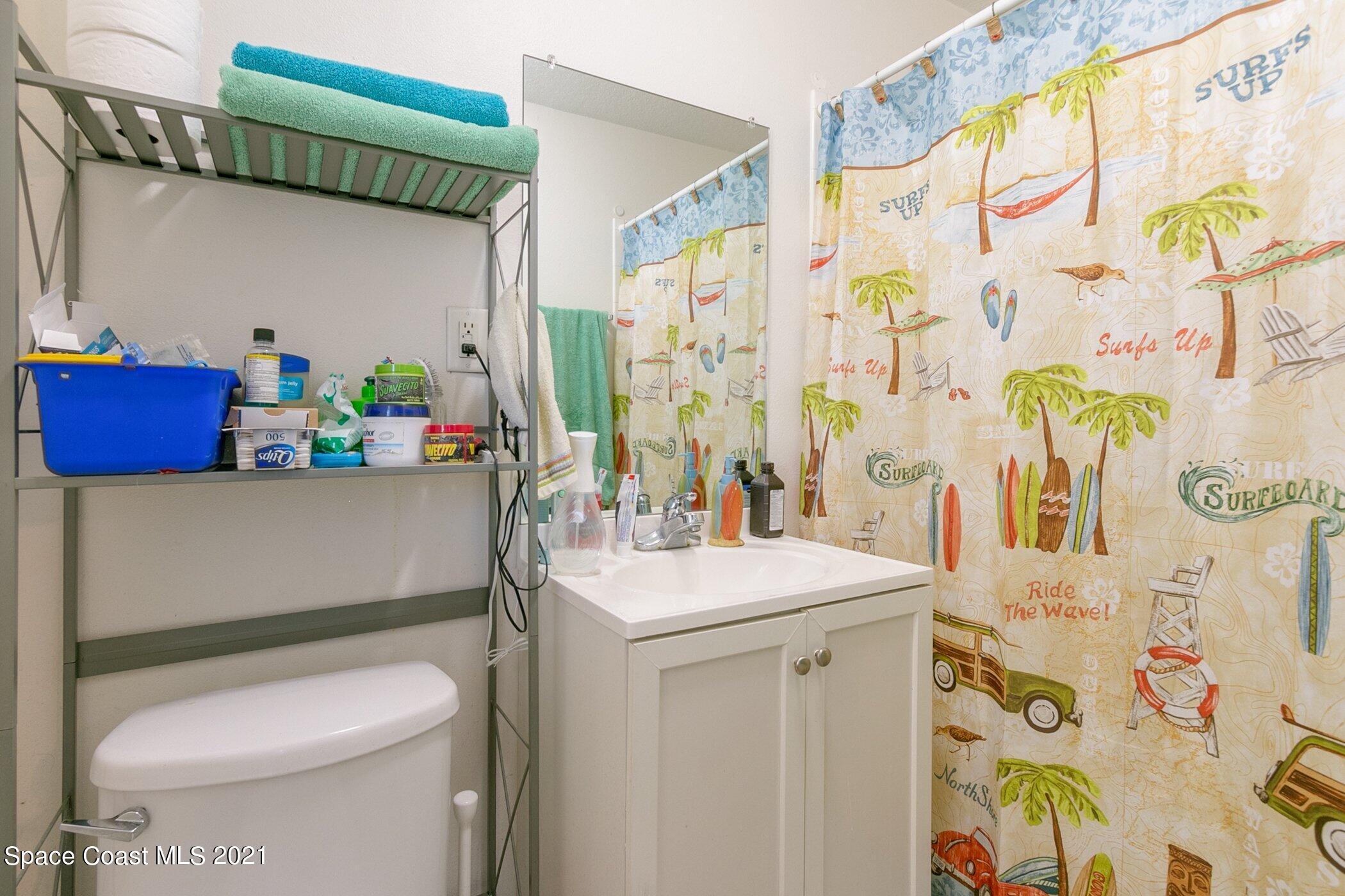 3222 Lipscomb Street Melbourne, FL 32901 - Photo 19 of 27 a bathroom with a sink a toilet and shower curtain