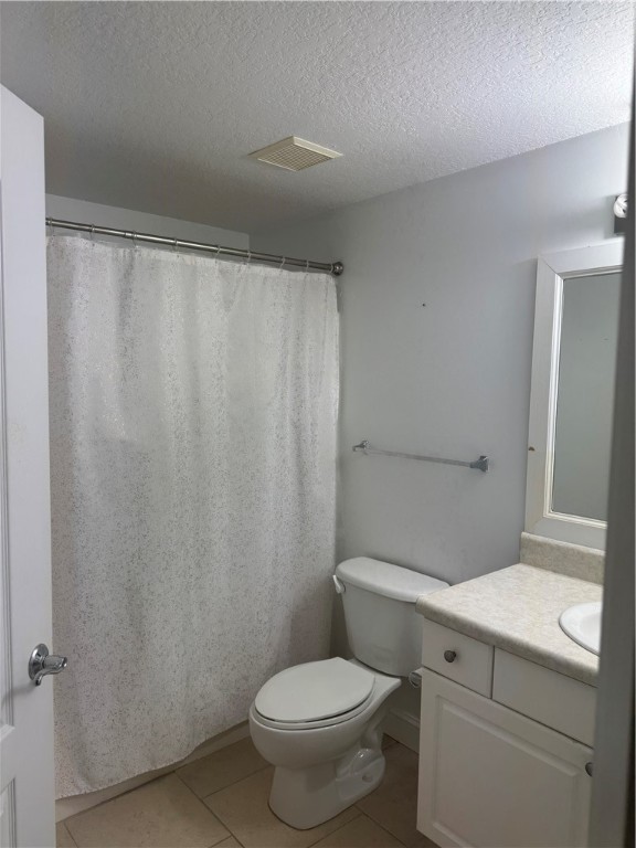 5060 Fairways Circle, Unit F207 Vero Beach, FL 32967 - Photo 11 of 14 a white toilet sitting next to a bathroom sink and vanity
